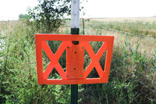 front side of orange multi post sign frame mounted to green and white metal t-post 
